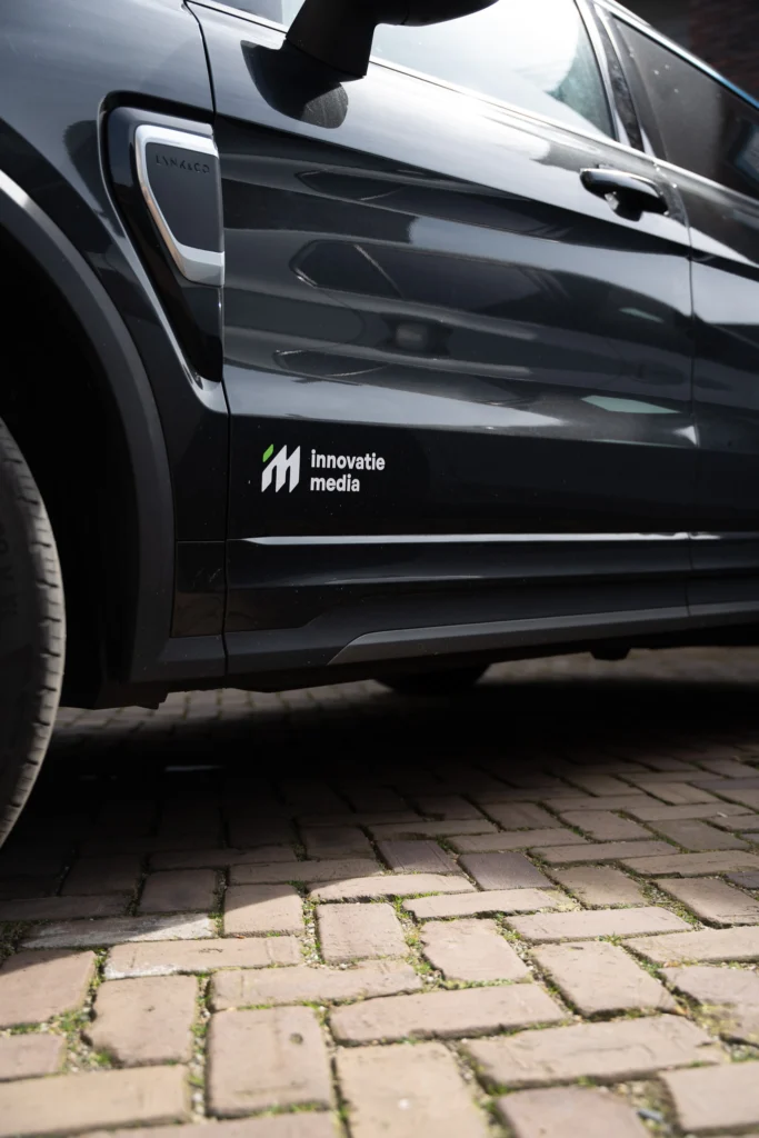 Auto met het logo van Innovatie Media op het portier