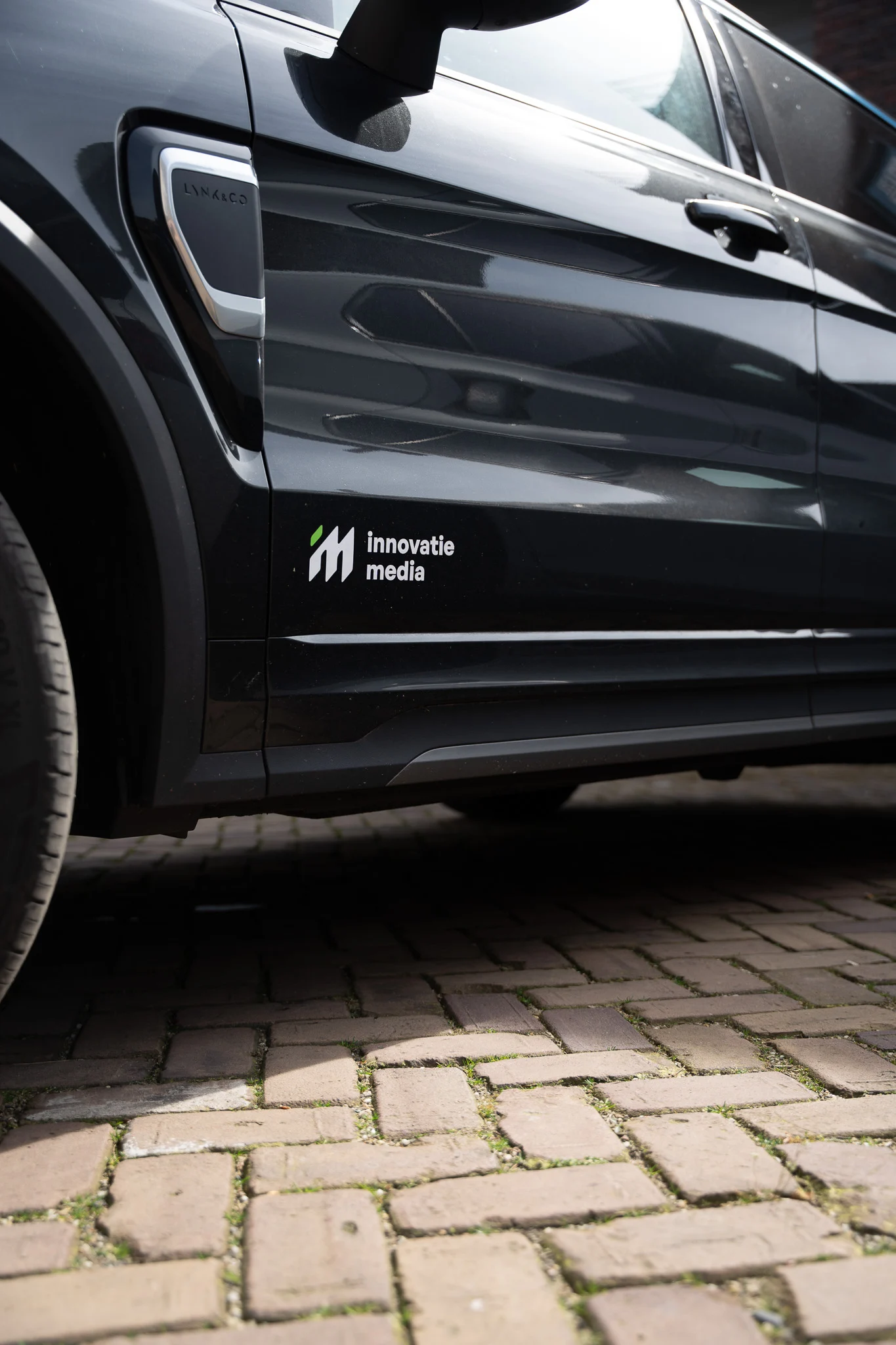 Auto met het logo van Innovatie Media op het portier