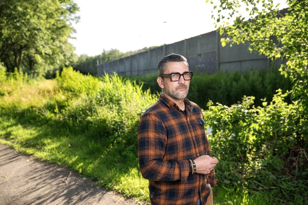 Man in een geruit overhemd langs een groen fietspad