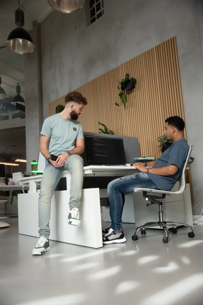 Twee collega's in gesprek bij een bureau