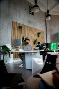 Collega's aan het werk bij de houten wand met het groene neonlogo