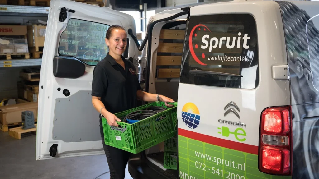 Bezorger met een krat bij een bestelbus van Spruit