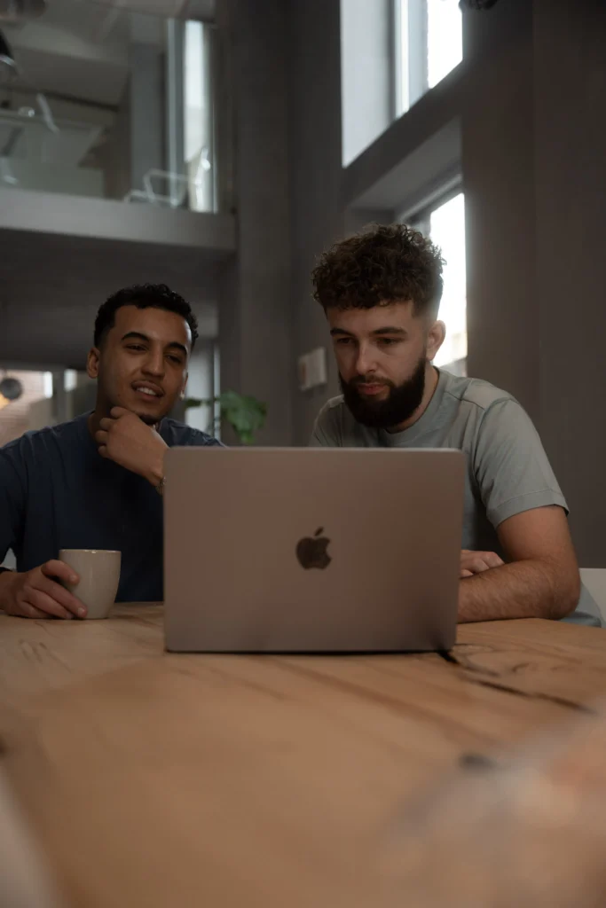 Twee collega's overleggen samen achter een laptop