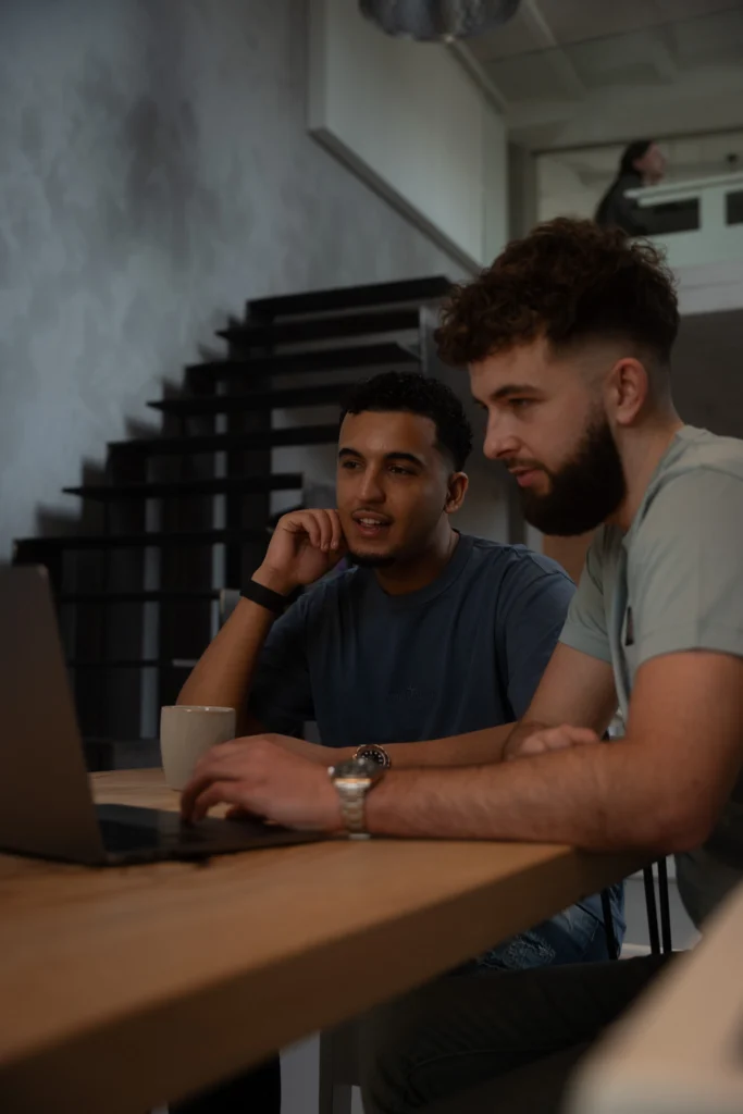 Twee collega's overleggen aan een tafel onder de trap