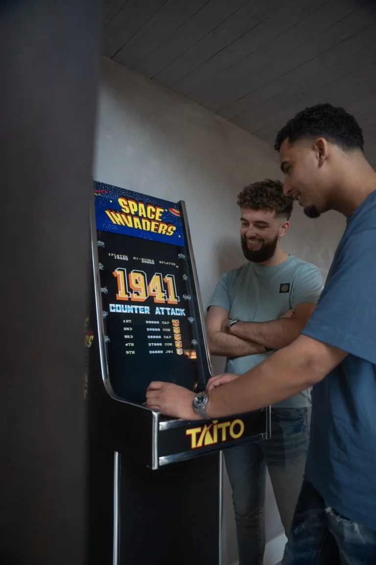 Twee collega's bij de Space Invaders-speelkast