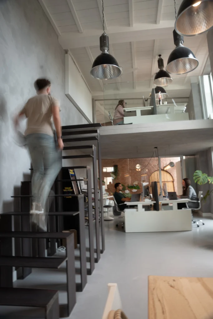 Collega loopt de trap op naar de vide van het kantoor